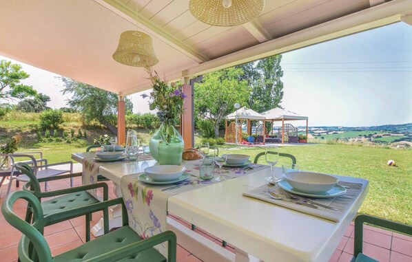 Enjoy a romantic meal under the shade of a pergola with a beautiful view of the surrounding hills.