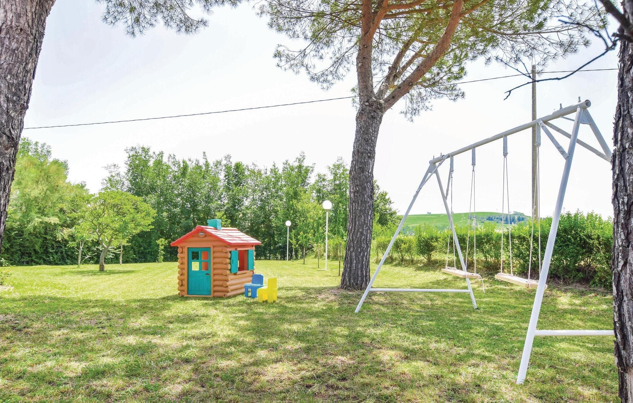 A playground with a swing set and a small playhouse.