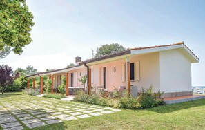 Stylish single-story home with a charming porch and lush green surroundings.