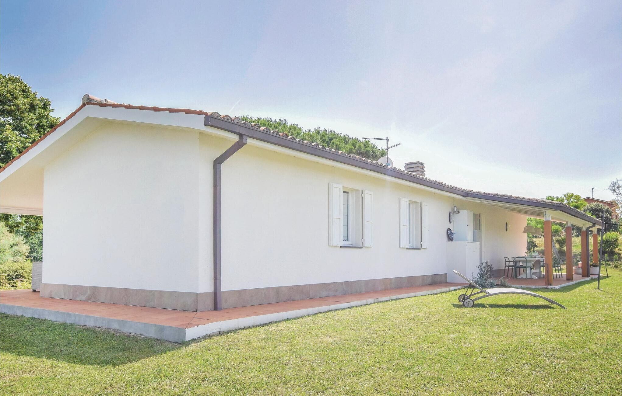 A single-story house with a flat roof, white exterior walls, and a small porch area.