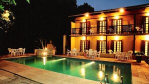 Ein zweistöckiges Gebäude mit Pool, Außenbereich und einem gut beleuchteten Balkon.