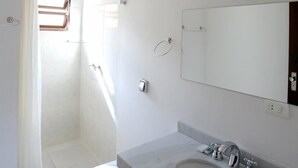 Ein modernes Badezimmer mit Toilette, Waschbecken und Dusche.