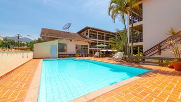 Een buitenzwembad en ligstoelen