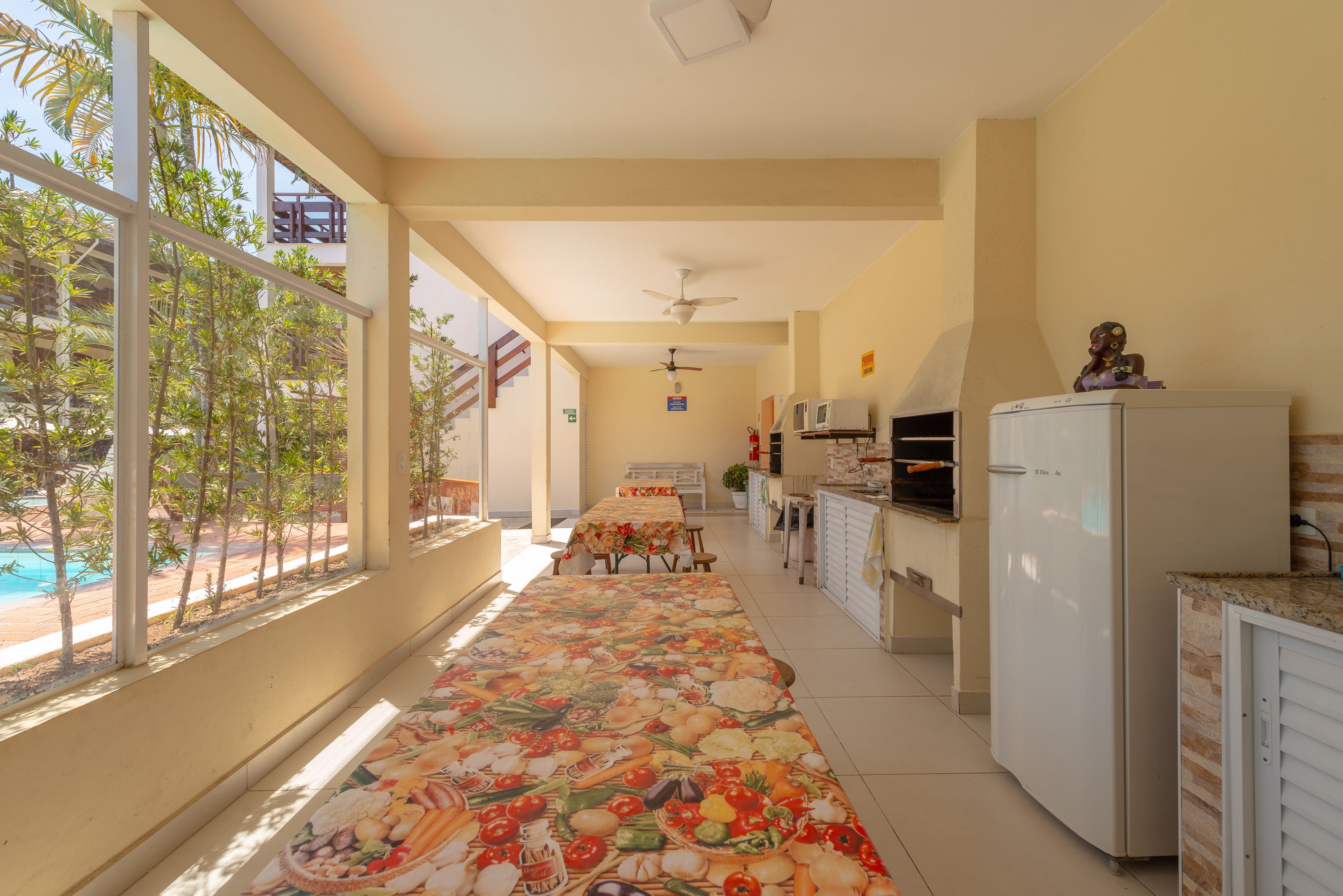 A kitchen with a long counter, a refrigerator, and a dining area with a table and chairs.