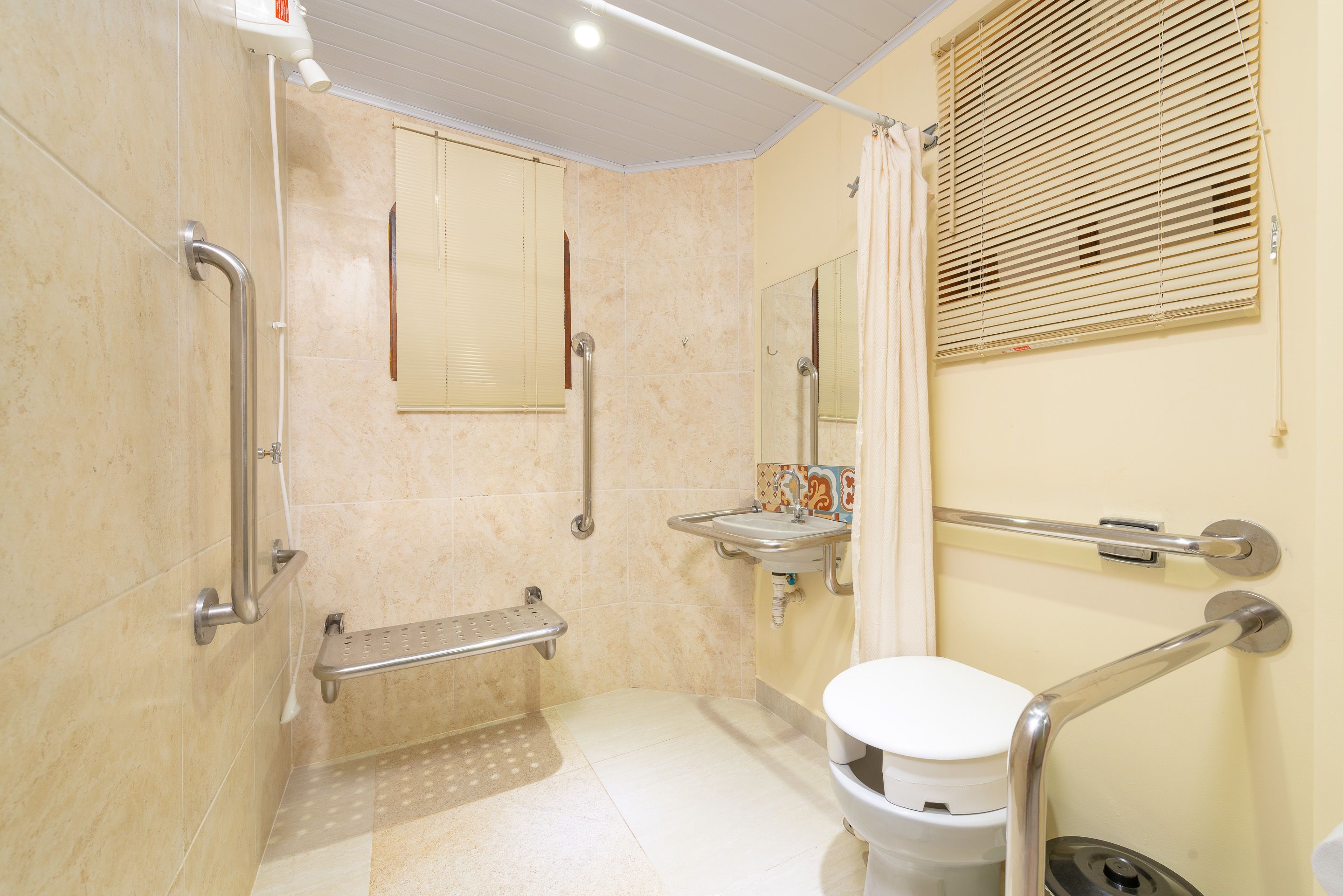 Un baño con inodoro, lavamanos y zona de ducha.