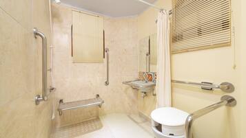 Un baño con inodoro, lavamanos y zona de ducha.