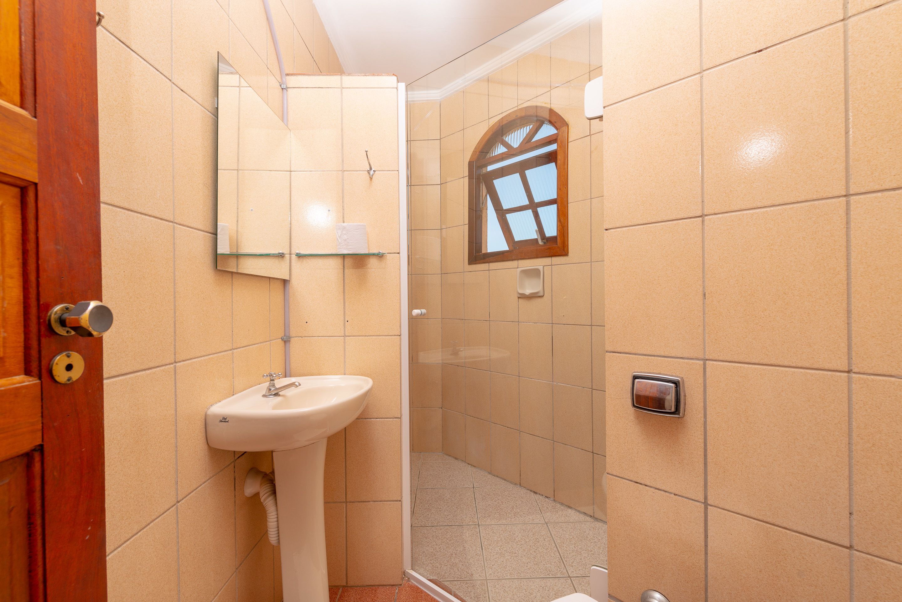 Un baño con lavamanos, espejo y ducha.