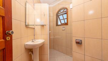 Un baño con lavamanos, espejo y ducha.