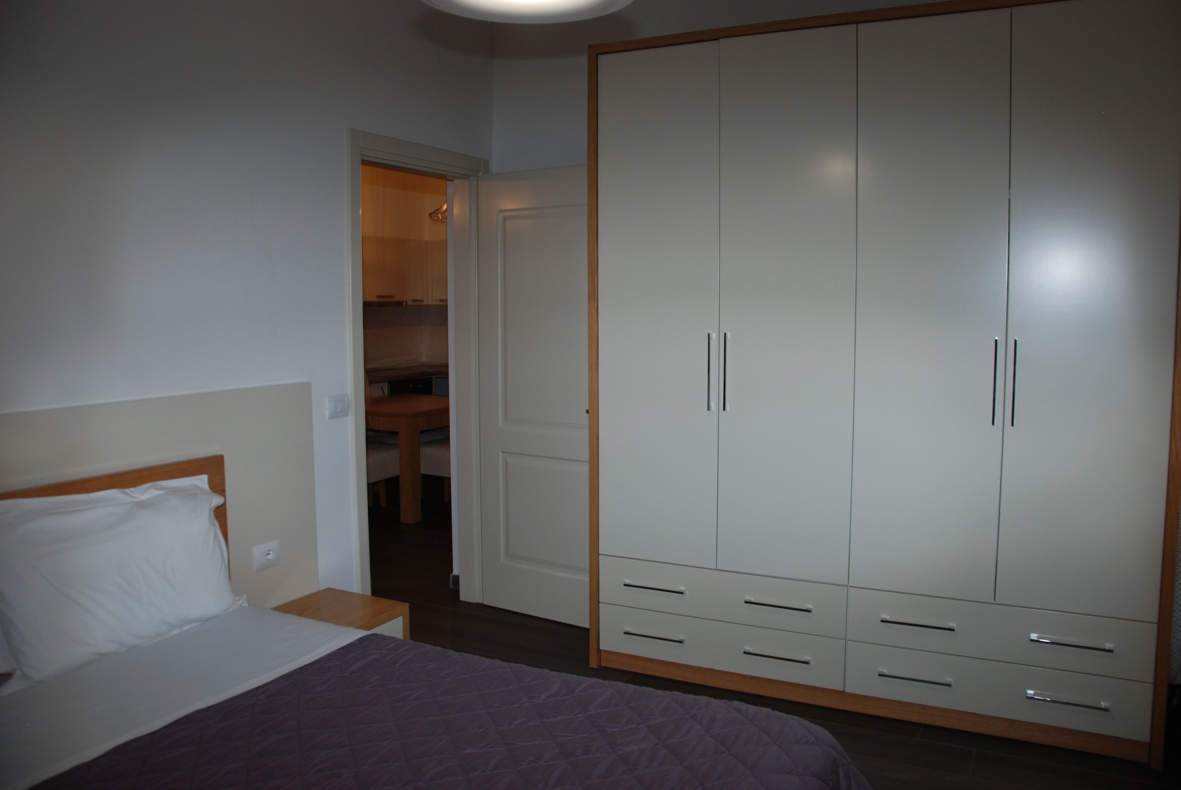 Une chambre à coucher avec un lit, une armoire et une petite table.