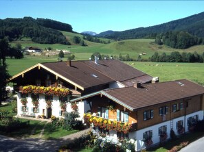 Guests can enjoy a serene rural setting with a traditional chalet-style building featuring a welcoming porch.