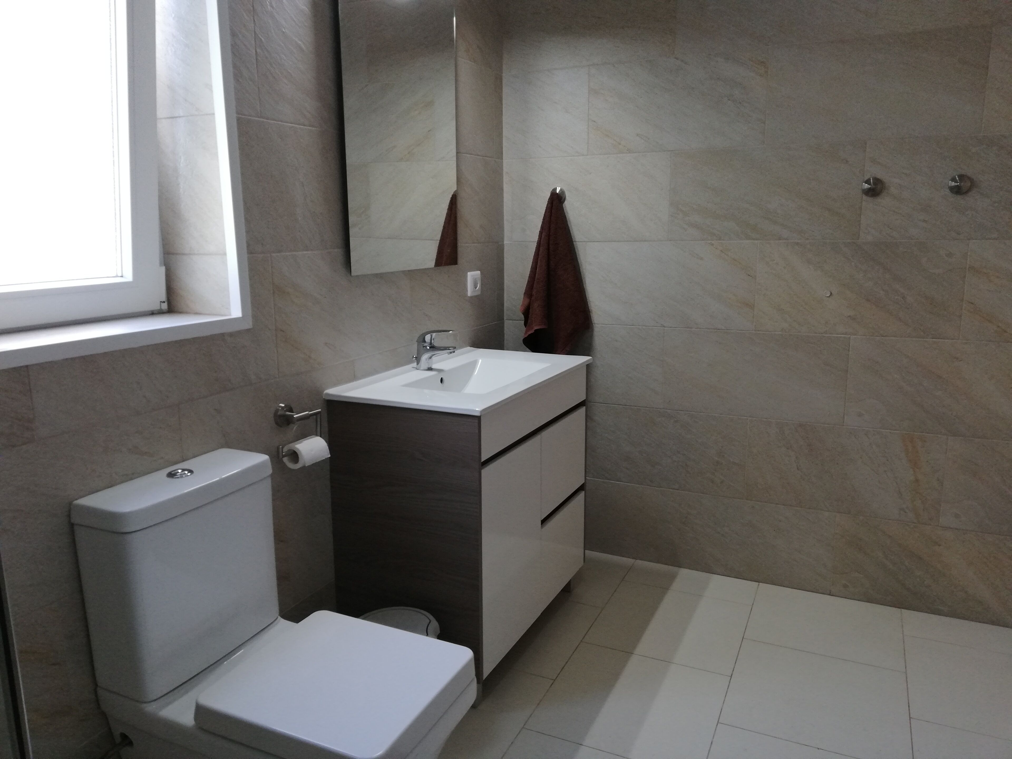 Une salle de bain moderne équipée de toilettes, d’un lavabo et d’un miroir.