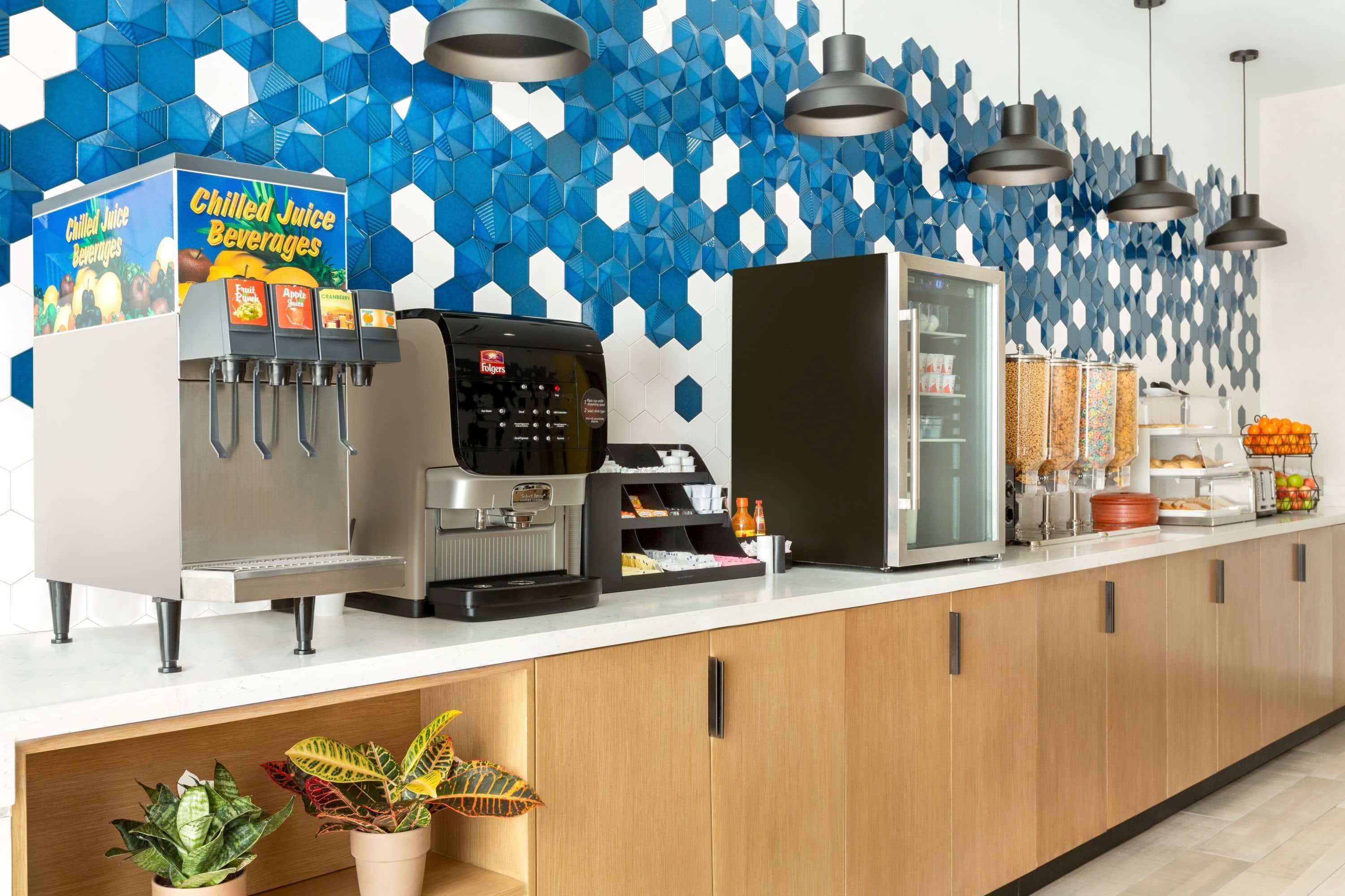 Eine Selbstbedienungs-Getränkestation mit Kaffeeautomat, Kühlvitrine und verschiedenen Getränkespendern.