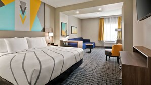 A hotel room with a large bed, a desk, a chair, and a TV. - La Quinta Inn & Suites by Wyndham Richmond-Sugarland (Richmond)