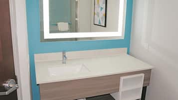 A bathroom with a white sink, a mirror, and a towel rack.