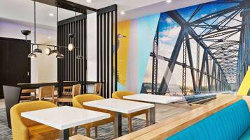 A modern interior with a long bench seating area, tables, and chairs.