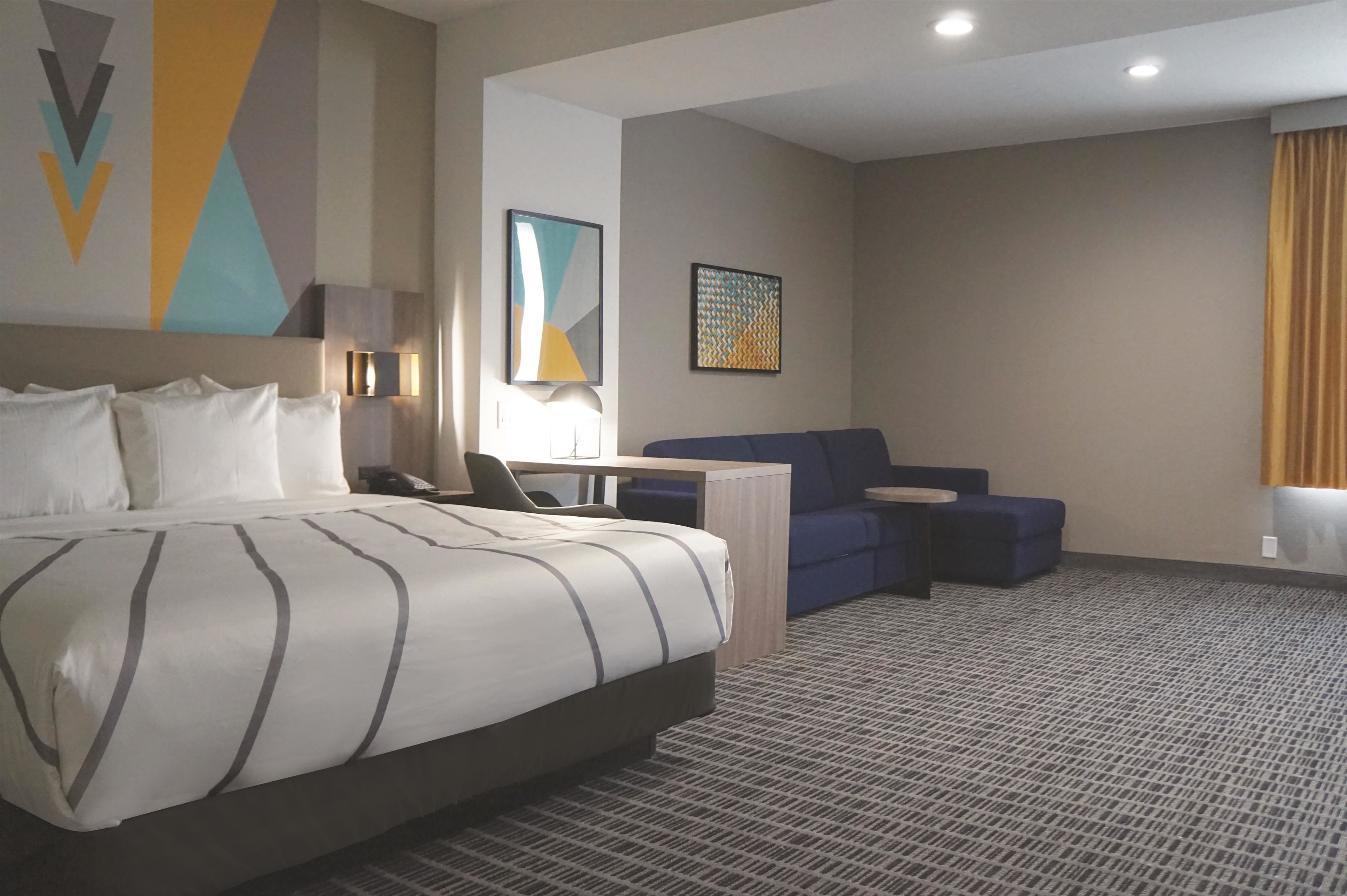 Een hotelkamer met een groot bed, een bureau, een stoel en een bank.