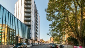 Un bâtiment moderne doté d’une façade en verre et de nombreux balcons.