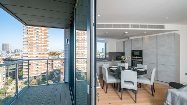 Un appartement moderne doté d’un balcon, d’un coin repas et d’une cuisine.