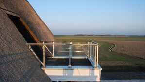 A high vantage point with a metal guardrail overlooking a field. - Directly at the Wadden Sea, part of UNESCO World Heritage. Calm/Fun at beach (Wierum)