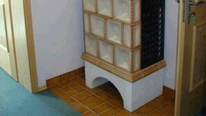 A corner room with a white wall, a wooden cabinet with glass doors, and a framed picture on top.