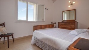 A bedroom with a bed, a chair, a dresser, a mirror, and a window. - 2 bedroom awesome home in Framura (SP) (Framura (SP))
