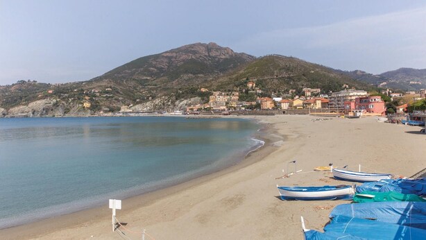 A beach with boats, a mountain, and buildings in the background. - 2 bedroom amazing home in Carro (SP) (Carro (SP))