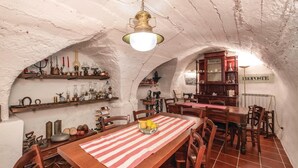 A rustic dining area with a wooden table, chairs, and a hanging light fixture. - 2 bedroom amazing home in Carro (SP) (Carro (SP))