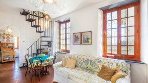 A cozy living room with a staircase, a dining area, and a sofa with patterned cushions. - 2 bedroom amazing home in Carro (SP) (Carro (SP))