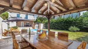 An outdoor wooden deck with a pool table, chairs, and a dining table with fruit and wine glasses. - Stunning home in Smrika with sauna (Smrika)