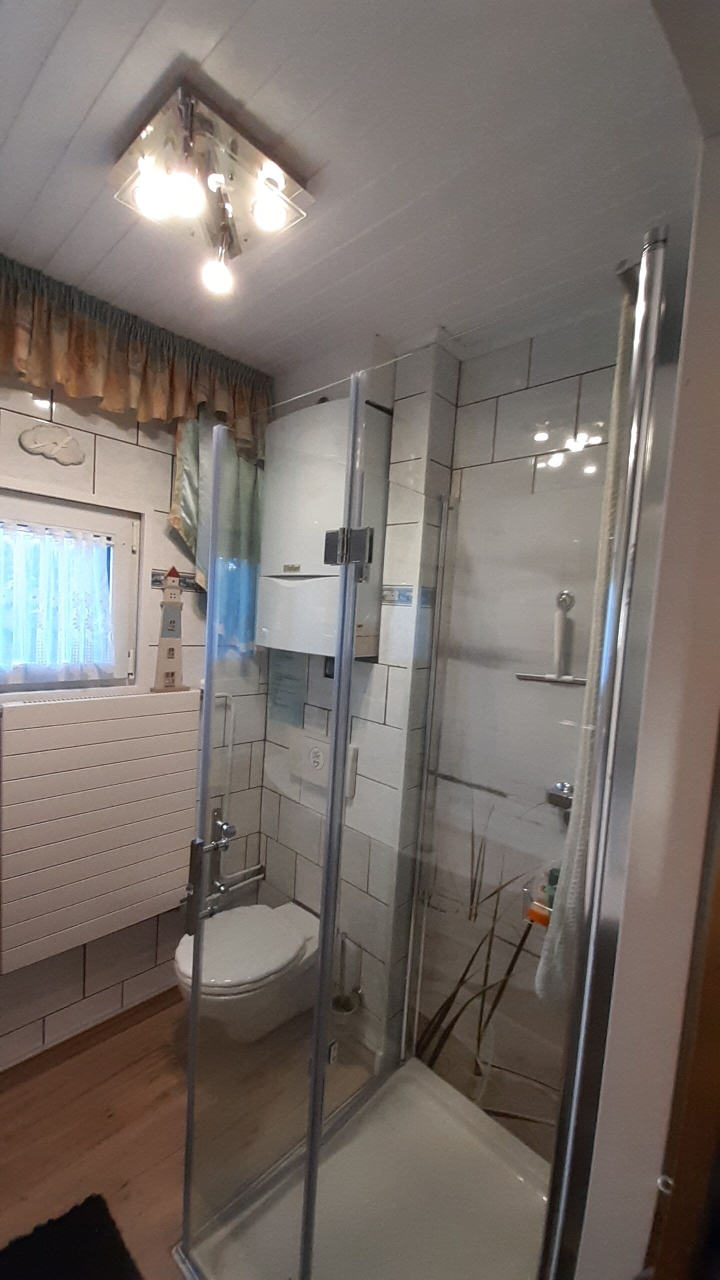 A modern bathroom with a glass shower enclosure, a toilet, and a sink.
