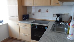 A kitchen with wooden cabinets, a dishwasher, a sink, and a coffee maker.