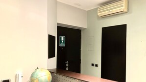 A reception desk with a globe, a phone, and a wall-mounted air conditioner. - Gemini Guest House (Rome)
