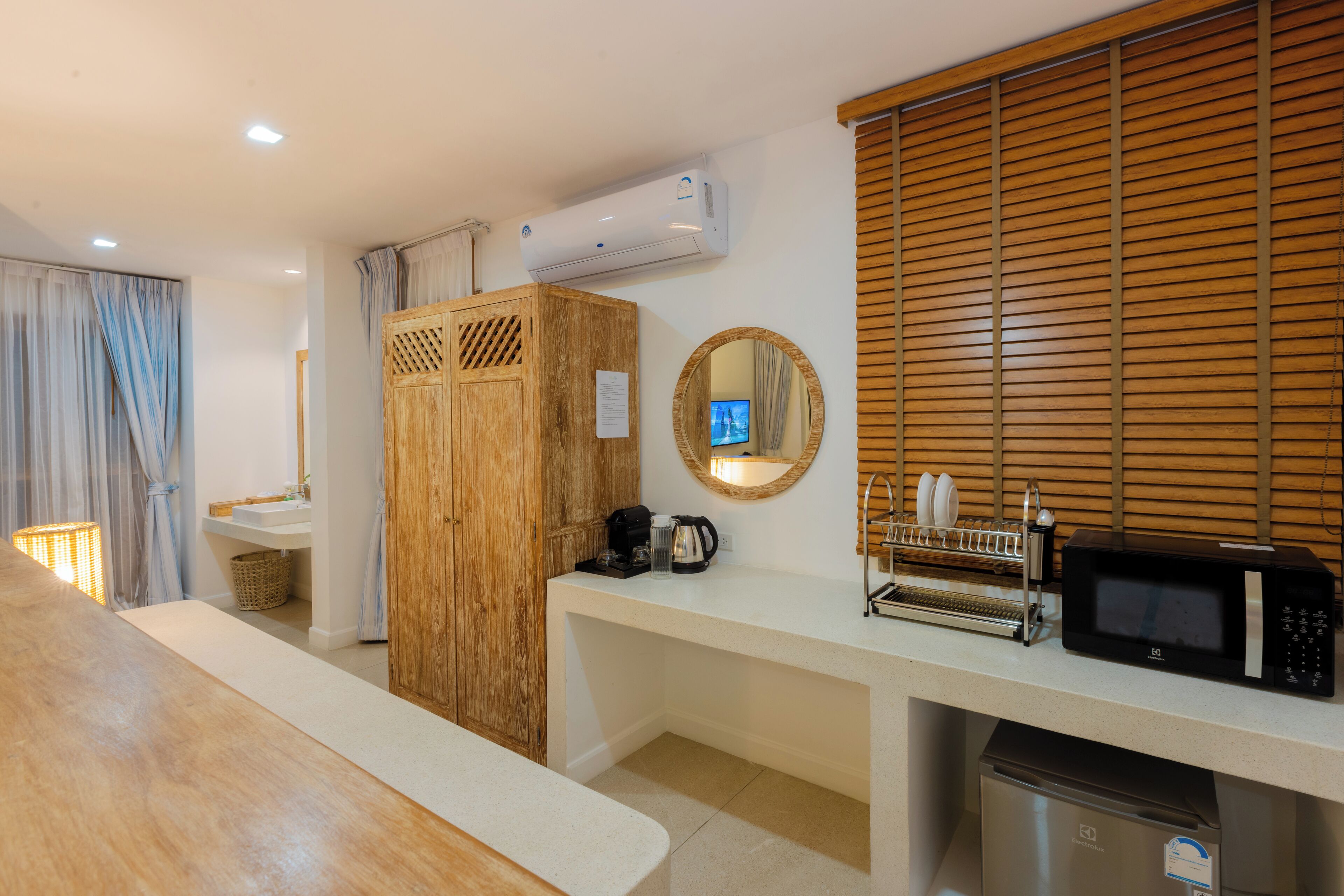 A modern kitchen with a wooden cabinet, a microwave, and a coffee maker.