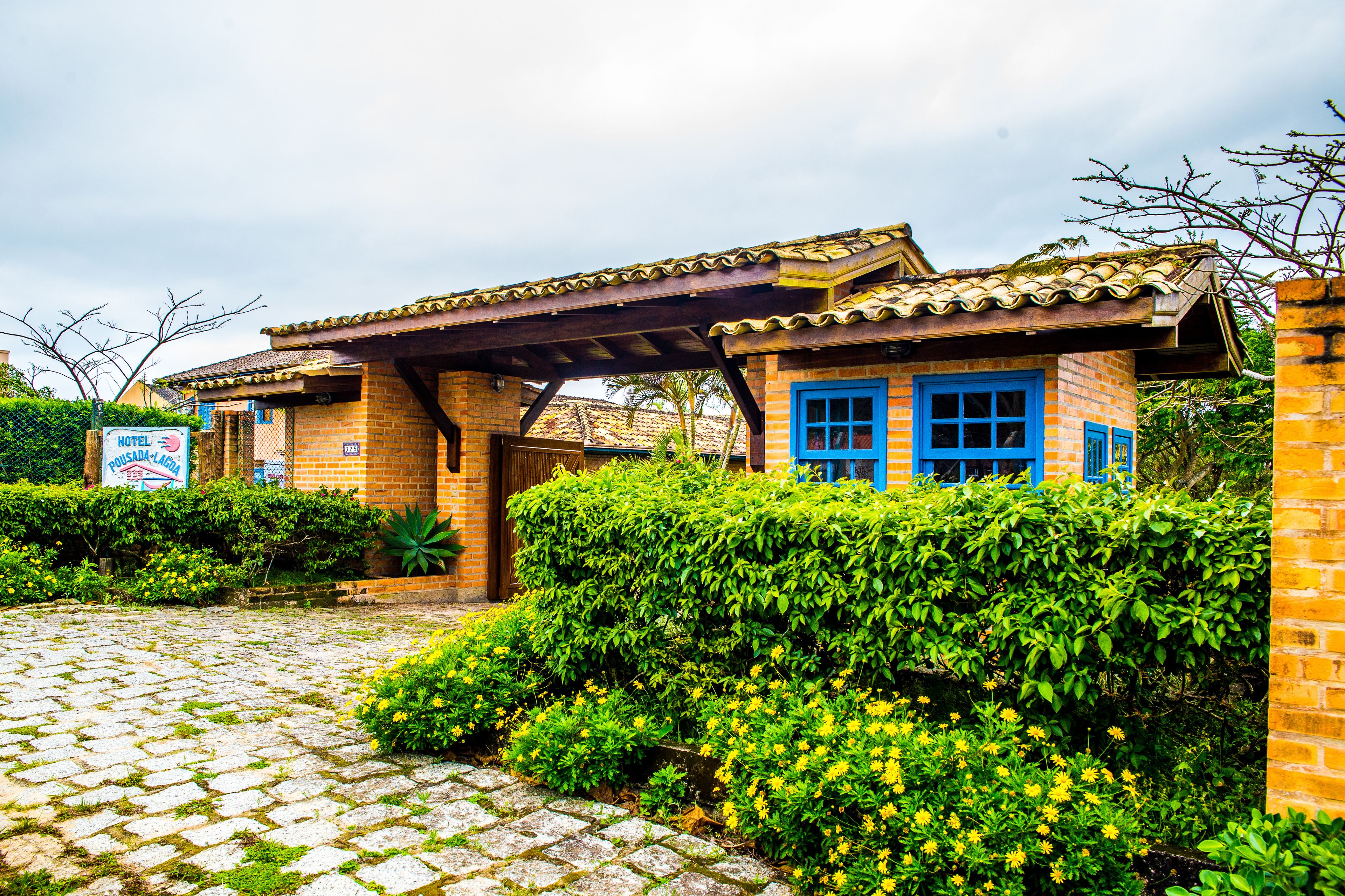 Um hotel com fachada de tijolos, portas azuis e telhado de telhas.