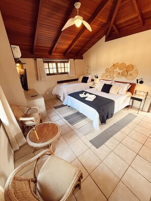 A bedroom with a bed, two bedside tables, a chair, a ceiling fan, and a window with curtains. - Pousada da Lagoa (Garopaba)
