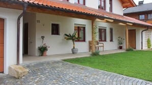 Ein zweistöckiges Haus mit Ziegeldach, gepflasterter Auffahrt und gepflegtem Rasen.