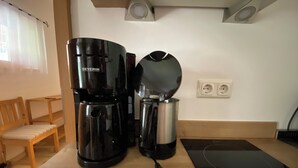 Eine Küche mit Kaffeemaschine, Wasserkocher und Mehrfachsteckdose auf der Arbeitsfläche.