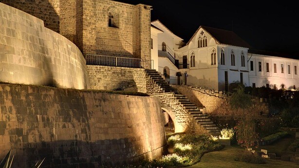 A historic stone building with a staircase leading to a white building with a red roof. - Qarmenqa Hotel (Cusco)