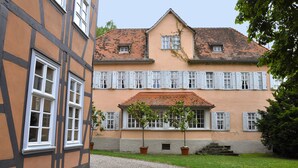 Un bâtiment à deux étages doté d’une façade traditionnelle, caractérisée par un mélange de charpente apparente et de murs en plâtre.