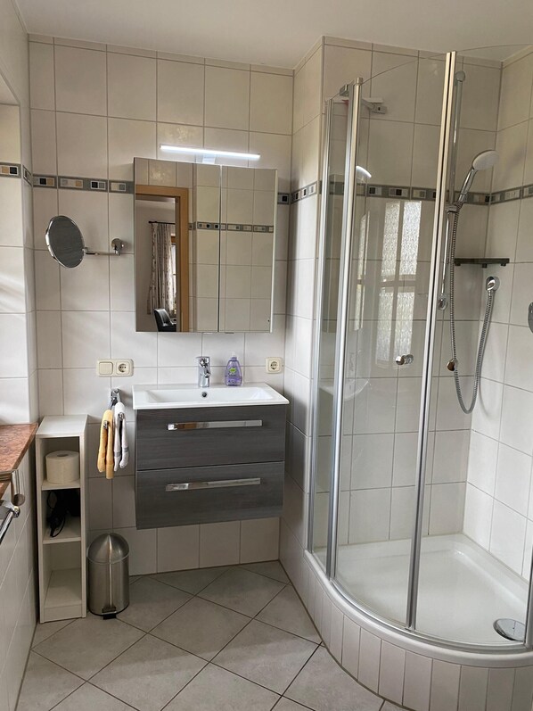 A modern bathroom with a glass-enclosed shower, a vanity with a mirror, and a toilet. - Ferienwohnung 2, 1-2 Personen - 43 qm - Nichtraucher, Balkon (Schönau am Königssee)