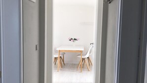 A hallway leading to a dining area with a white table and chairs. - CITY FLAT Center Freudenstadt opposite Kurhaus  (Freudenstadt)