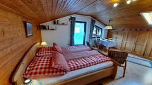 Ein gemütliches Schlafzimmer in einer Holzhütte mit einem Bett, einem Schreibtisch und einem Stuhl.