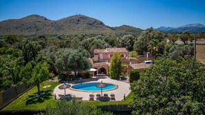 A villa with a swimming pool, surrounded by lush greenery and mountains in the background. - Finca Toni in Alcudia with pool close to the beach (Alcúdia)