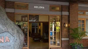 A building entrance with a large stone, the name "HELEHA" above the door, and a potted plant outside. - Helena Guest House (Malang)