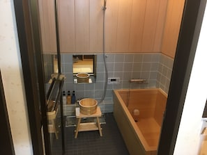 Bathroom features a bathtub, showerhead, and sink with a mirror above.