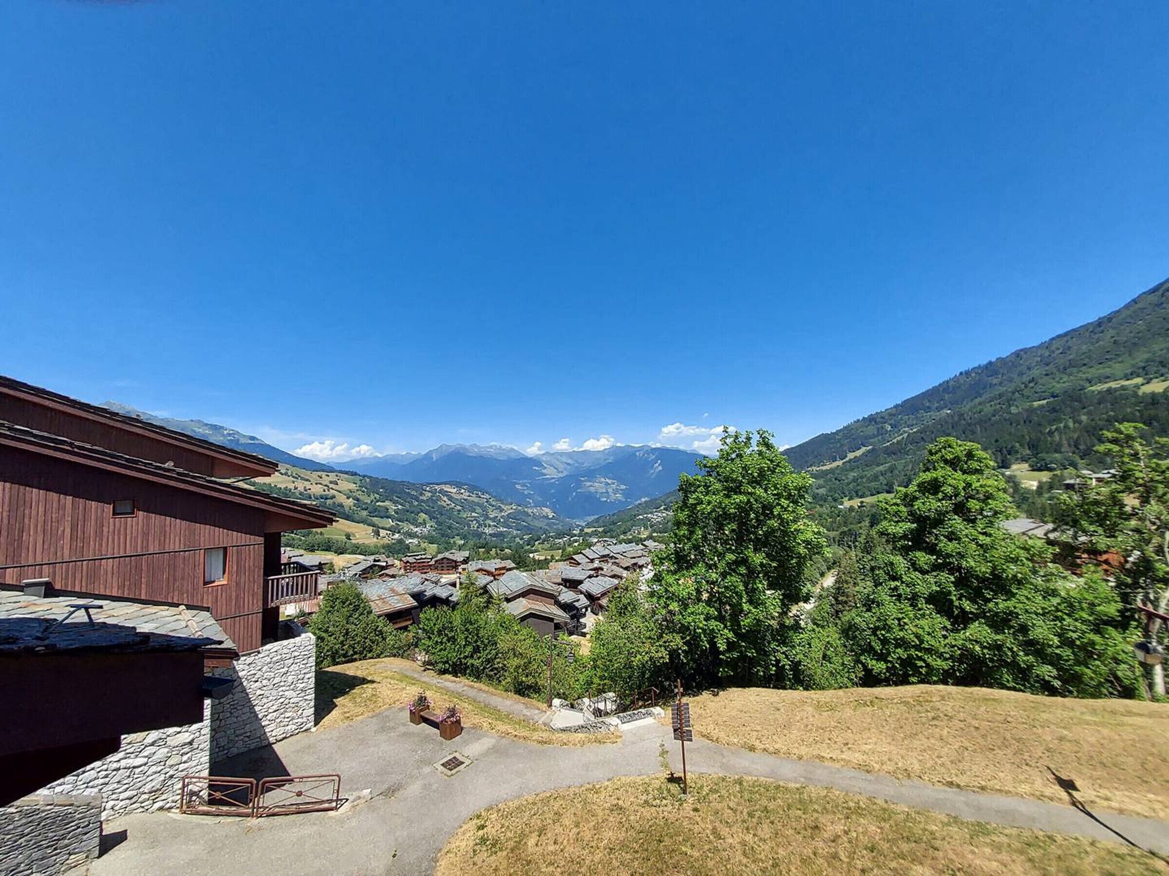 Blick auf Berge mit einem Holzhaus und einer Steintreppe.
