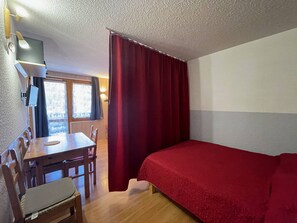 Una habitación con cama, escritorio y silla.