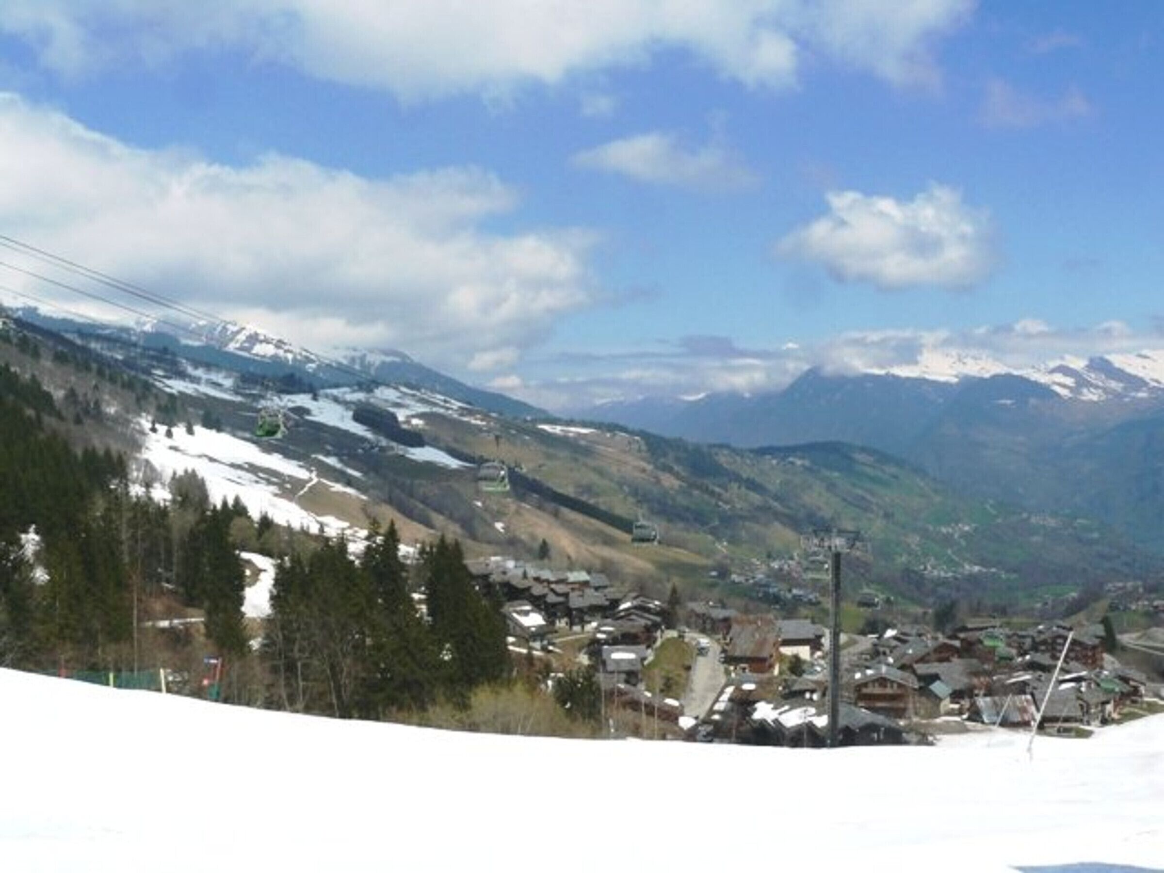 Un pueblo de montaña con laderas nevadas y cielo despejado.
