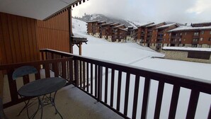 A balcony with a view of a snow-covered mountain and buildings.