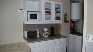 A compact kitchenette with a microwave, toaster, coffee maker, and cabinets. - Valley view apartment (Saint-Lary-Soulan)